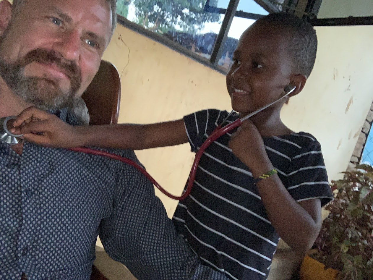 Nelson's daughter Faith using a stethoscope on a visitor to the family in Moshi