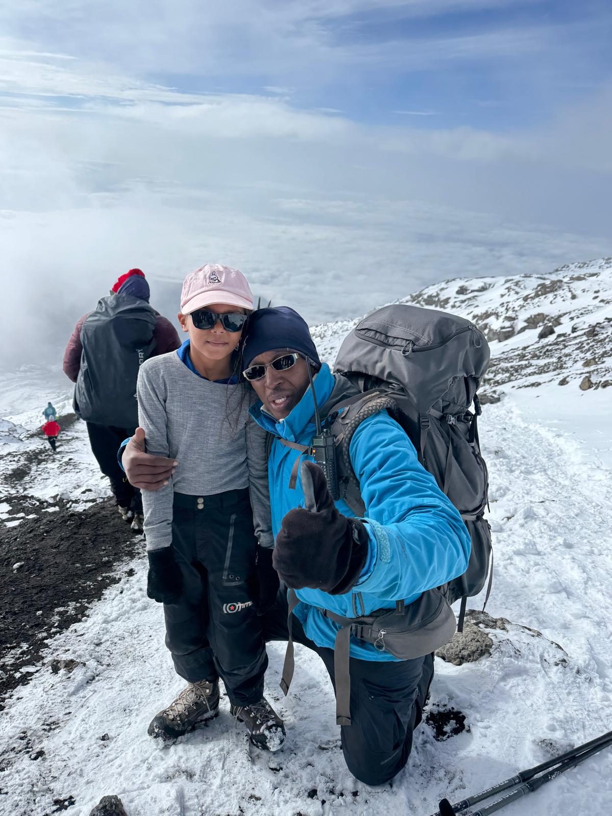 Nelson with a young climber above the clouds near Stella Point on Kilimanjaro