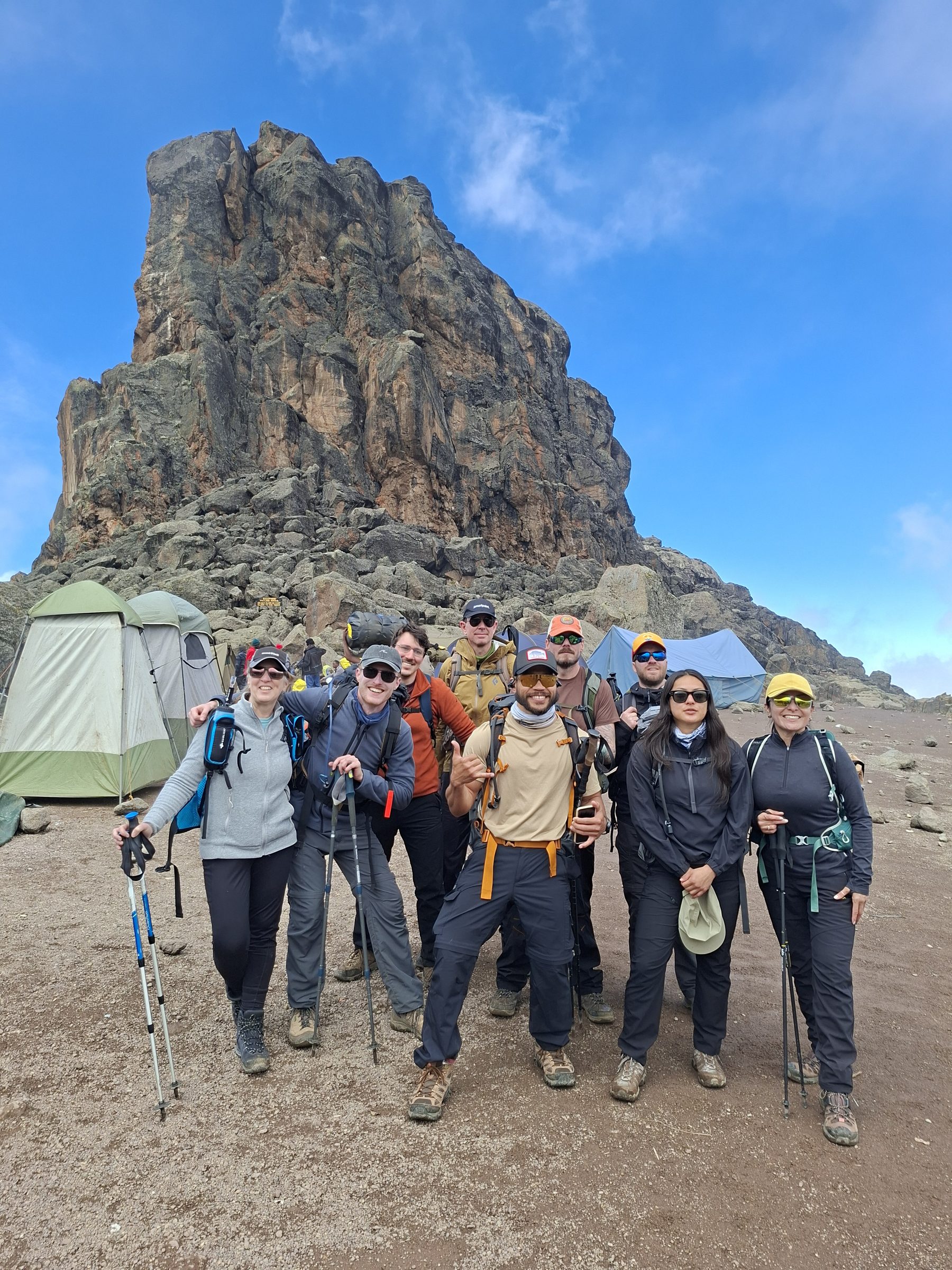 A Kilimanjaro trekking team resting together below the rocks on an acclimatisation day