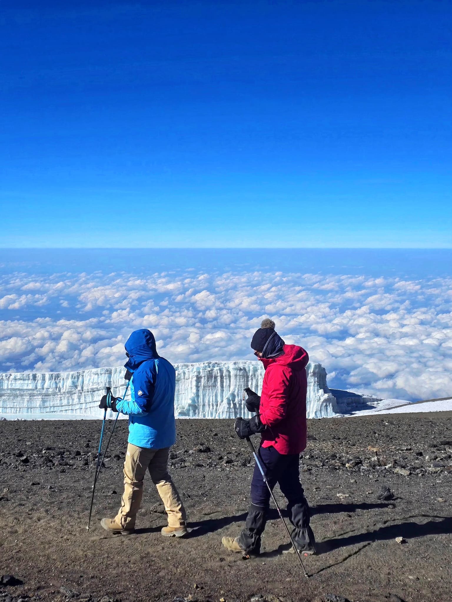 Walking past the glacier wall on the summit, above the cloud sea.