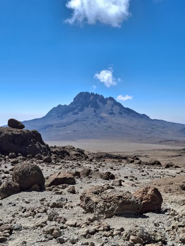 Mawenzi Peak seen across the boulder-strewn Saddle from near Kibo Hut, one small cloud above the summit.