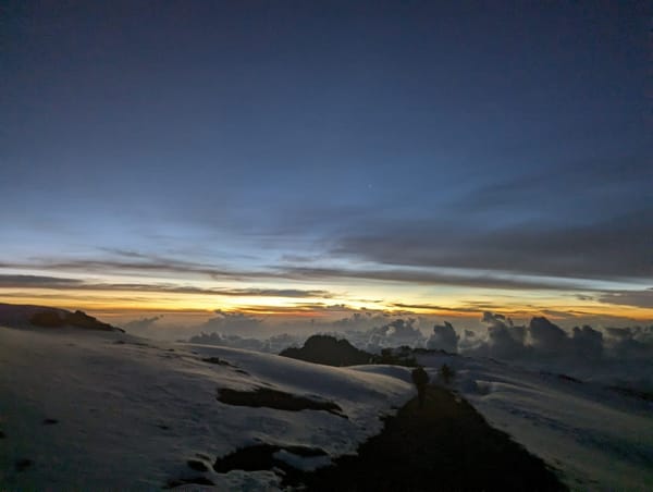Dawn on the summit snow plateau, Mawenzi rising from the cloud sea.