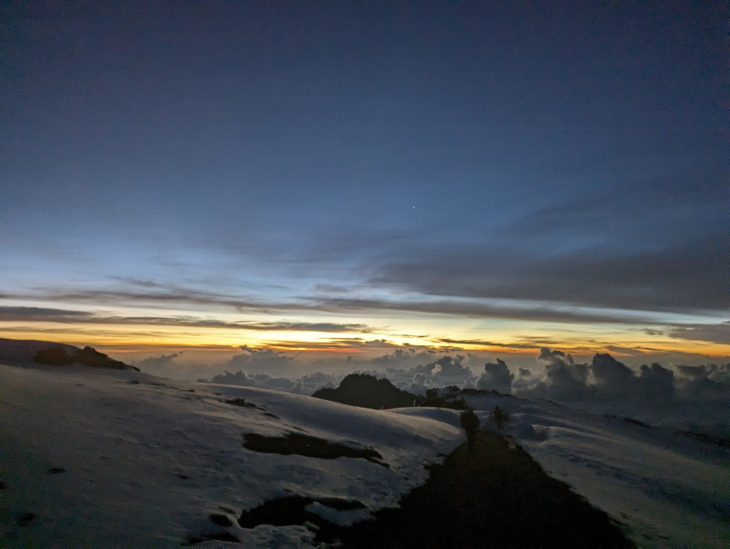Dawn on the summit snow plateau, Mawenzi rising from the cloud sea.
