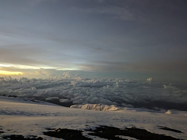 Sunrise over Mawenzi from the summit zone, sunburst over the cloud sea.