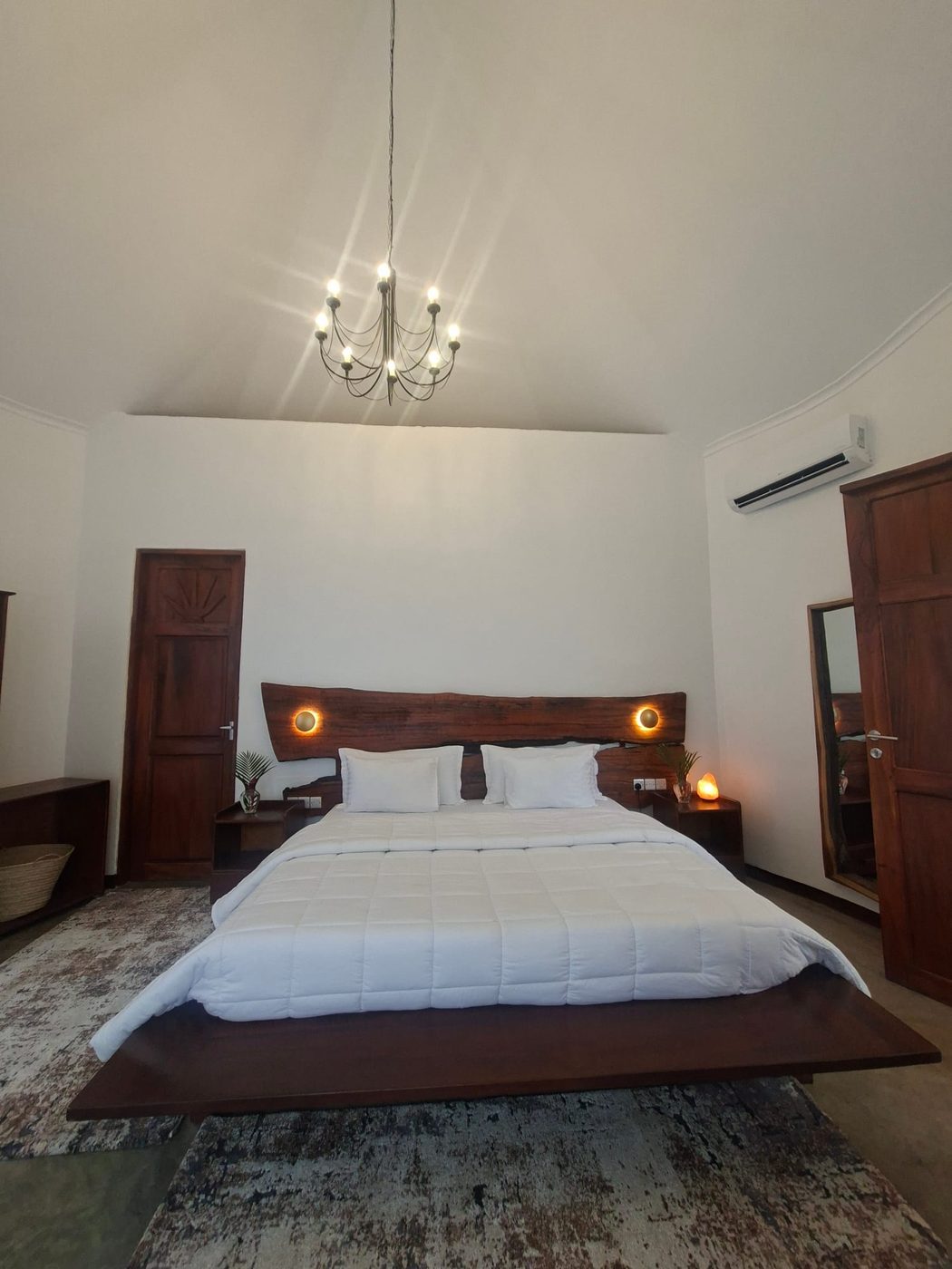A spacious en-suite bedroom with a king bed and hardwood furniture at Tulivu guesthouse in Moshi
